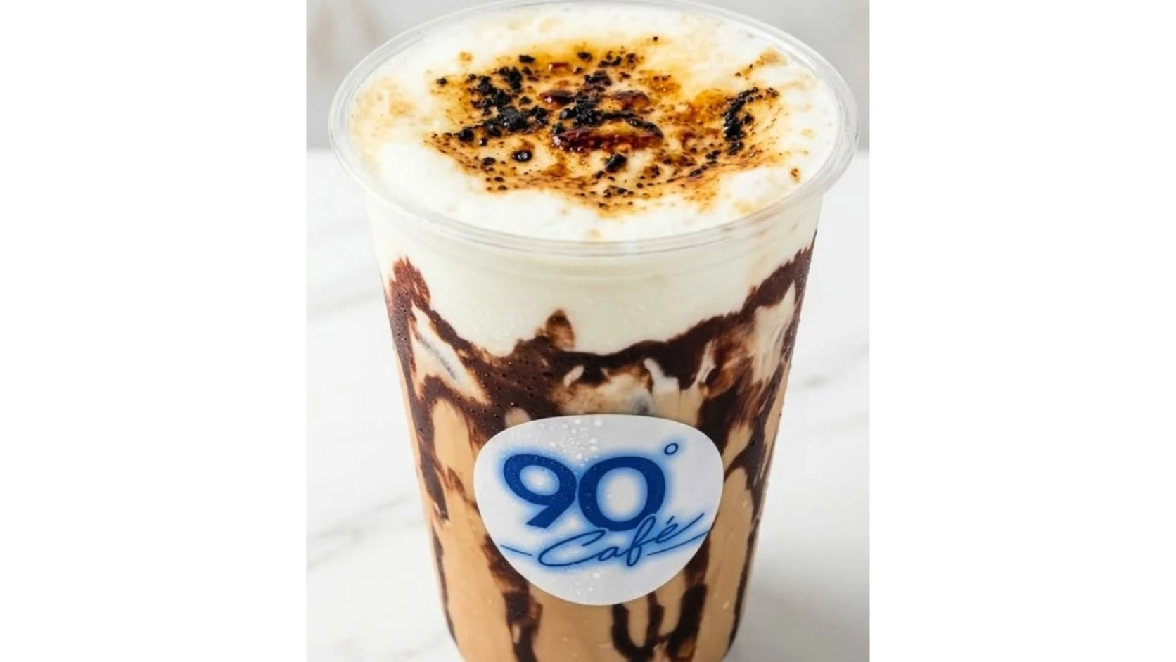 A 90° Café branded iced latte with a toasted creamy topping