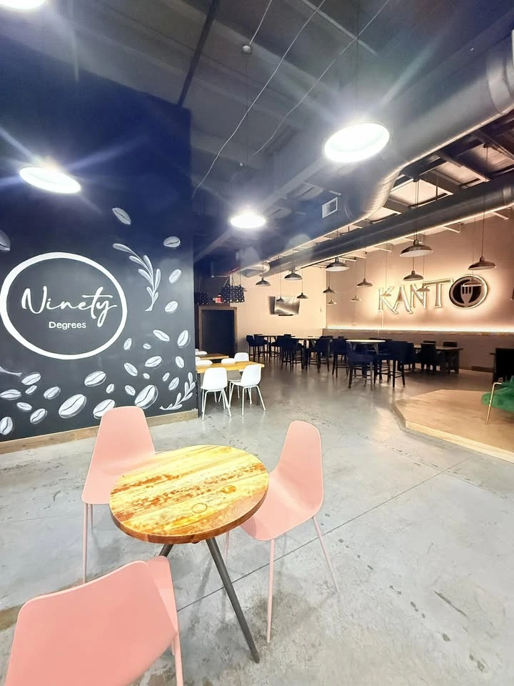 The actual café interior with a Ninety Degrees wall graphic, pink chairs and tables