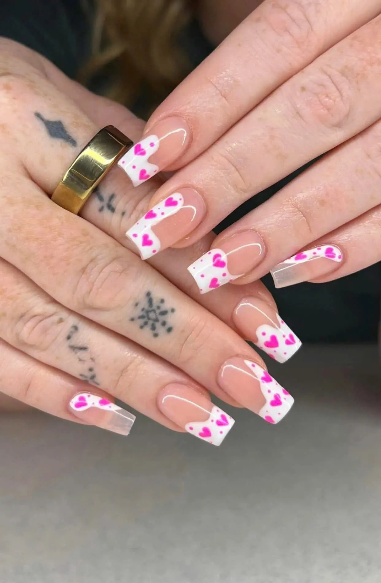 Square white French tip nails with pink painted hearts