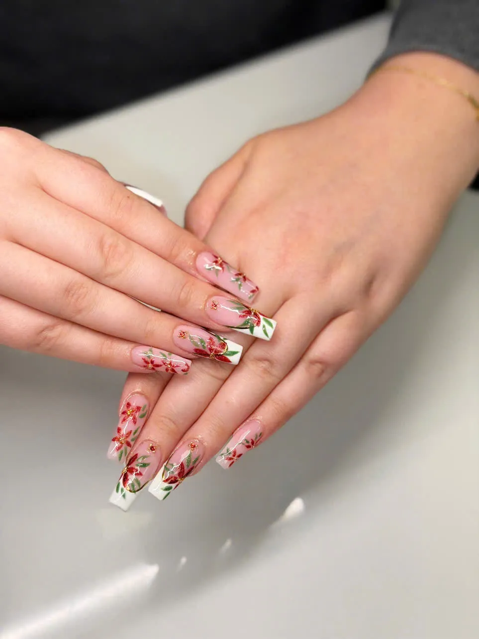 Long coffin nails with white tips and hand-painted red poinsettia florals
