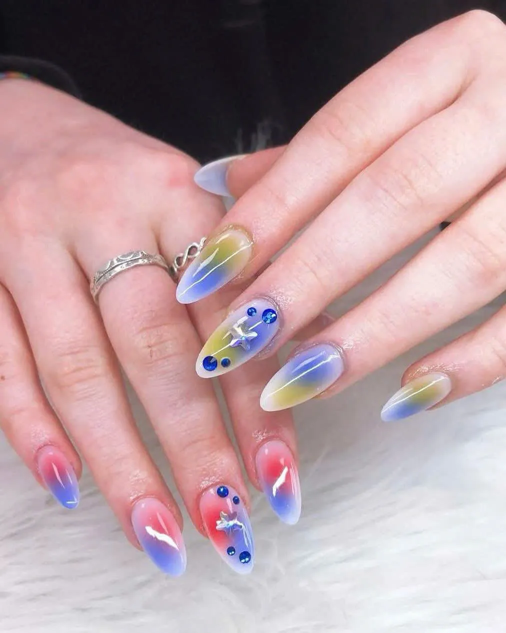Almond nails with blue and yellow aura ombre, stars and rhinestones